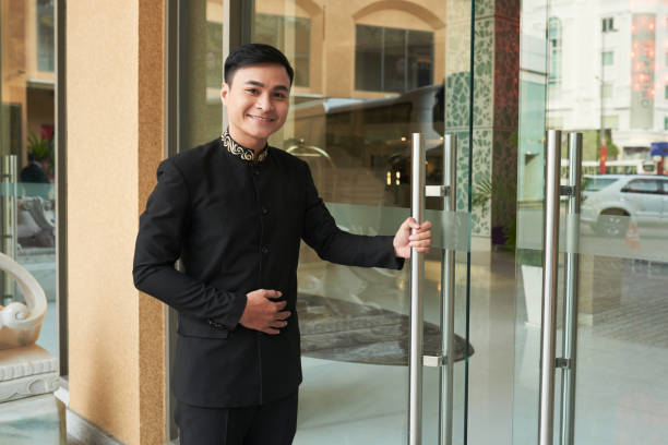 Smiling doorman standing at hotel entrance